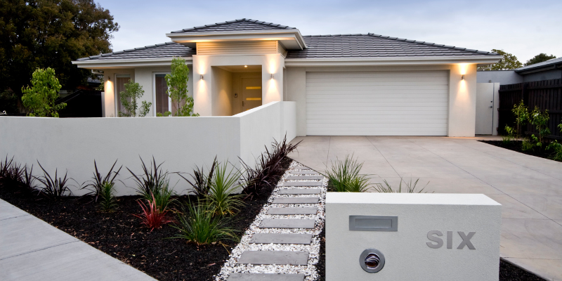 Modern white garage door and landscaping in a luxury Emirates Hills villa